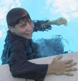 Wet teenager swimming in clothes